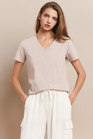 A woman wearing a light mocha V-neck cotton t-shirt with short sleeves.