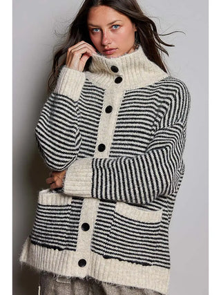 A woman wearing a black and white striped knit cardigan with a fold-over collar and button front.