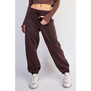 Espresso-colored jogger pants with elastic waistband and cuffs, shown on a model.