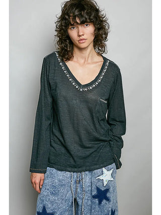 A black V-neck knit top with hand-stitch detailing and a chest pocket, worn by a model.