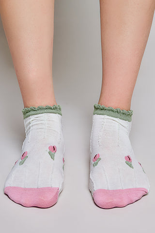 White ankle socks with a pink and green floral pattern and green scalloped trim.