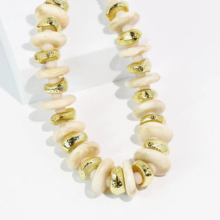 Ivory and gold disc necklace with textured gold accents.