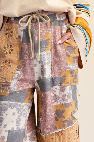Terry knit pants with a colorful patch print featuring floral and animal motifs, drawstring waist.