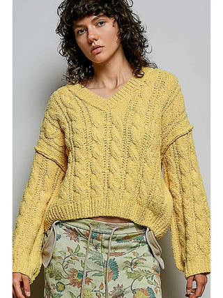 Yellow semi-cropped V-neck sweater with soft knit texture worn by a person.