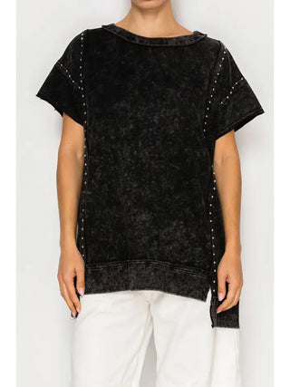 Black mineral wash top with studded detailing, short sleeves, and asymmetrical hem.