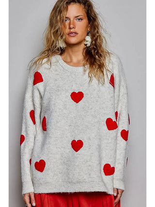 Cream knit sweater with red heart pattern, featuring a crew neck and long sleeves.