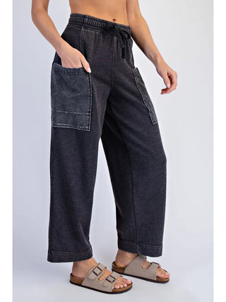Black cropped cargo pants with mineral wash effect, elastic waistband, and large side pockets.