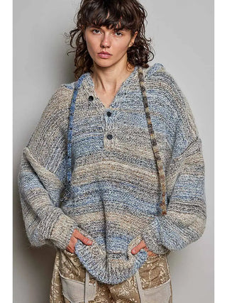 A woman wearing a space dye knit sweater in blue multi with a hood and button front.