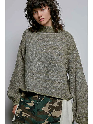 A model wearing an olive high-neck sweater with rolling edges and a relaxed fit.