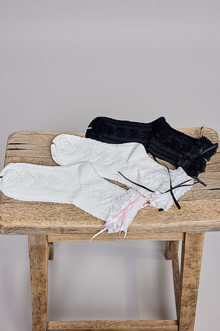 Black and white textured knit crew socks displayed on a wooden surface.
