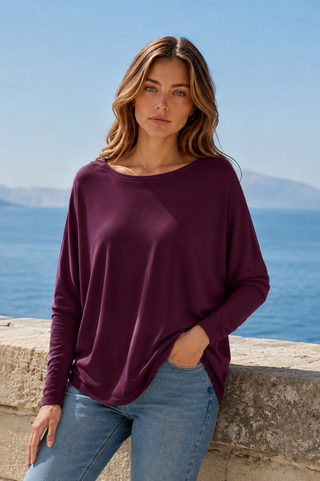 Woman wearing a relaxed-fit long-sleeve top in cabernet with a boat neckline.