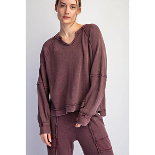 A woman wearing a dark cherry waffle raglan long sleeve top with a relaxed fit.