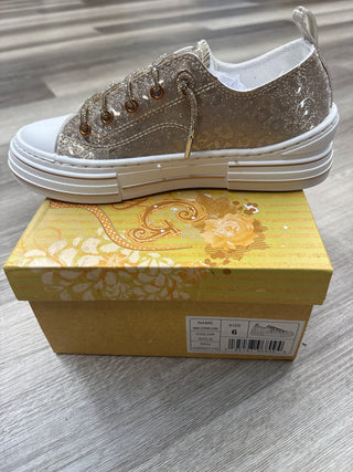 Gold glitter sneakers with leopard pattern and lace-up design on a decorative box.