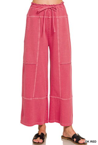 Dark red wide leg pants with exposed seams and elastic drawstring waist.
