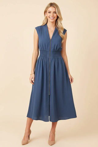 Navy sleeveless midi dress with a smocked waist and full front zip, worn by a model with heels.