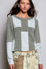A woman wearing a waffle knit contrast patchwork top in deep matcha with long sleeves.