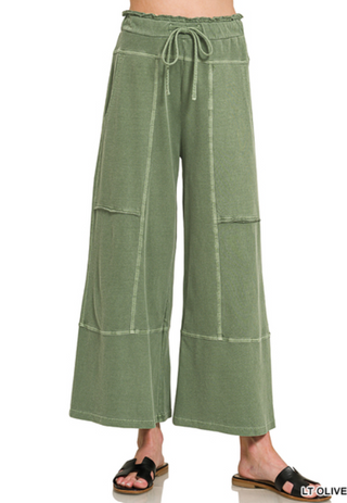 Wide leg pants in light olive with exposed seams and a drawstring waist.