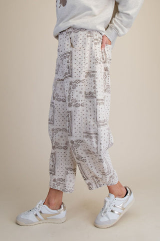 Barrel pants with a bandana print in ecru, shown with a casual outfit and sneakers.
