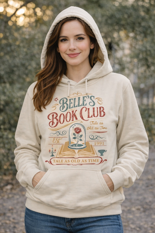 Woman wearing a hoodie with 'Belle's Book Club' design outdoors.