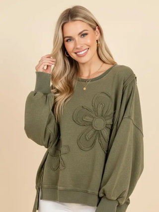 Olive sweatshirt with floral applique and puff sleeves worn by a model.