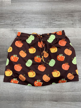 Brown shorts with a multicolor pumpkin print, featuring an elastic waistband and drawstring.