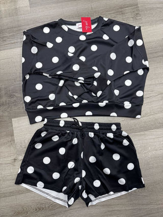 Black pullover and shorts set with white polka dots, featuring long sleeves and an elastic waistband with drawstring.