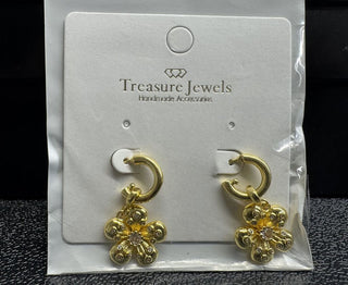 Gold hoop earrings with intricate flower charms on a display card.