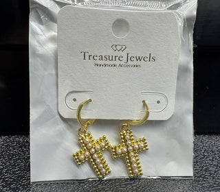 Gold cross earrings with pearl accents on a display card.