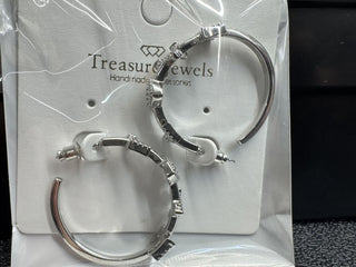 Silver hoop earrings with crystal accents on a display card.