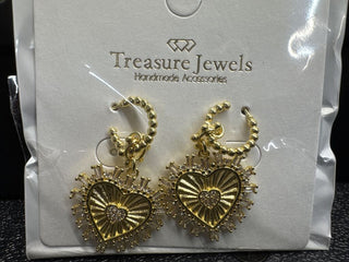 Heart-shaped gold earrings with crystal accents and burst design on a display card.