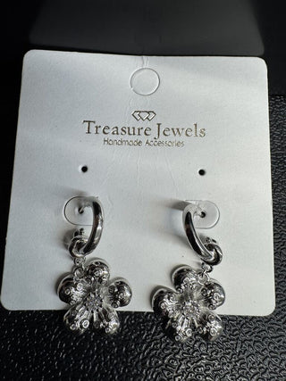 Silver floral drop earrings with intricate design and polished finish on a display card.