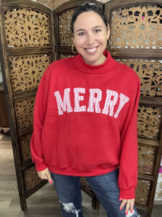 A red sweatshirt with 'Merry' embroidered in white, featuring a mock neck and long sleeves.